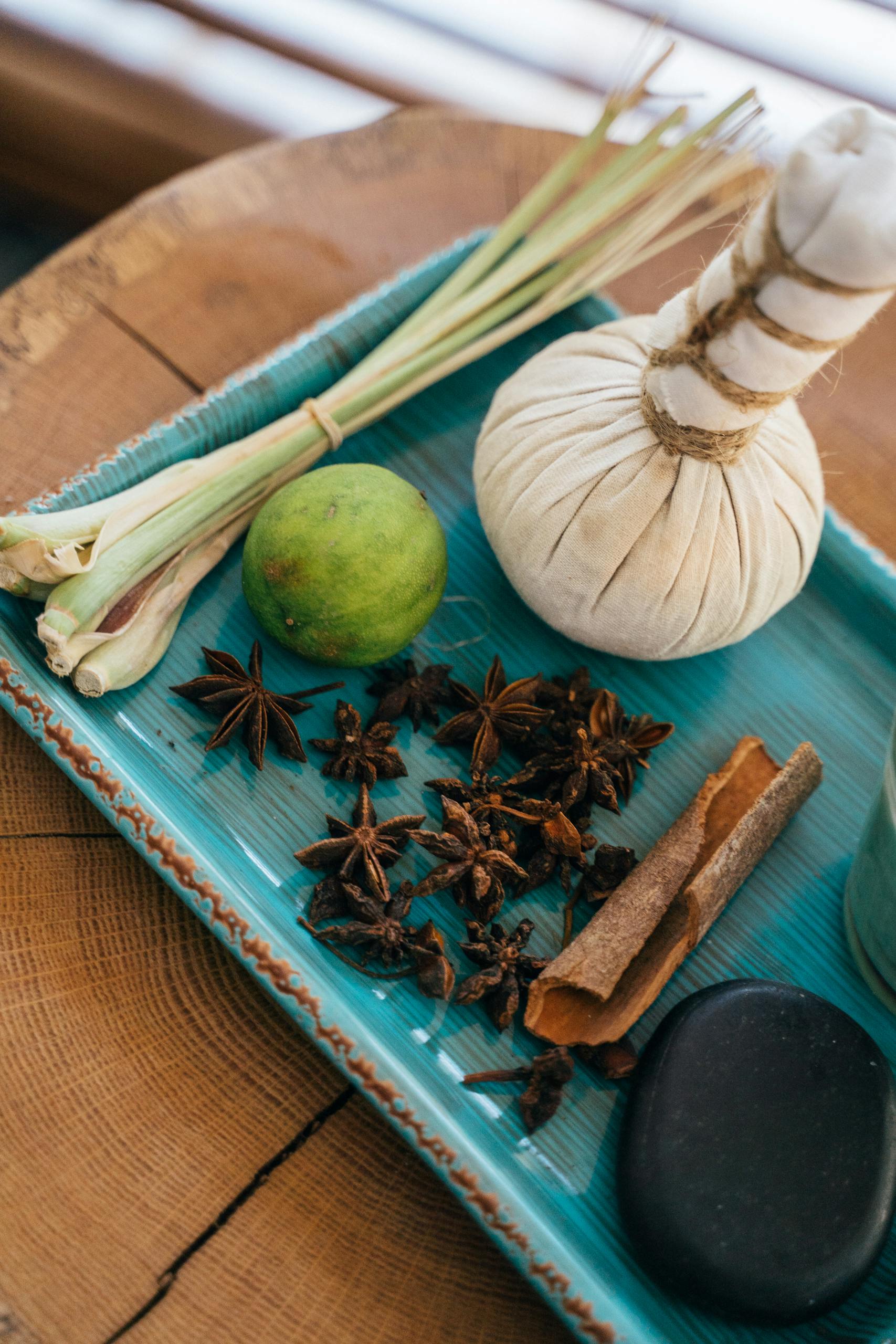 Flat lay of aromatic herbs and spa elements on a rustic tray for holistic beauty treatment.